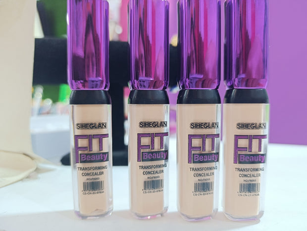 A tube of SHEGLAM FIT Beauty Transforming Concealer in a sleek design with a wand applicator.