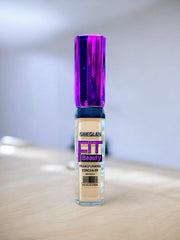 A tube of SHEGLAM FIT Beauty Transforming Concealer in a sleek design with a wand applicator.